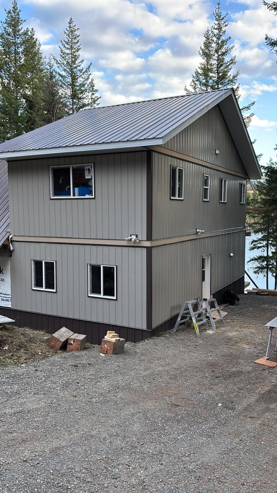 Completed two-storey cabin addition with siding and metal roofing